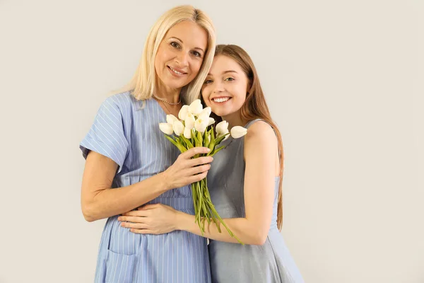 Young Woman Greeting Her Mother Tulips Grey Background — Stock Photo, Image
