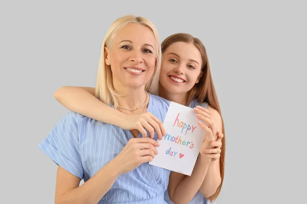 Jovem Cumprimentando Sua Mãe Com Cartão Fundo Cinza — Fotografia de Stock