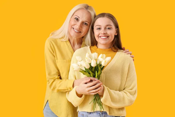 Giovane Donna Che Saluta Sua Madre Con Tulipani Sfondo Arancione — Foto Stock