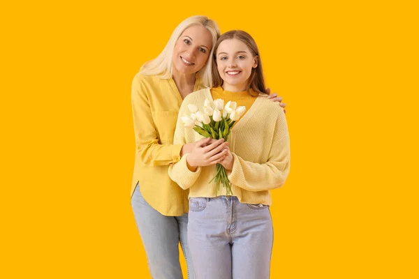 Young Woman Greeting Her Mother Tulips Orange Background — Stock Photo, Image