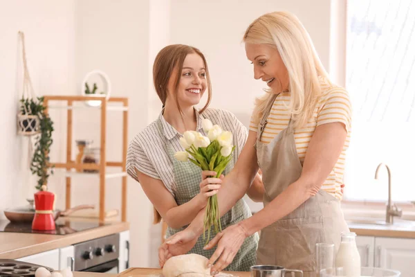 Молодая Женщина Приветствует Свою Мать Тюльпанами Кухне — стоковое фото