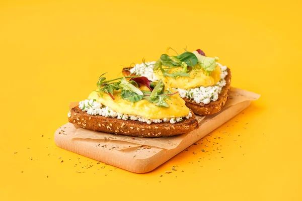 노란색 배경에 맛있게 스크램블드에그 샌드위치와 녹색을 곁들인 — 스톡 사진