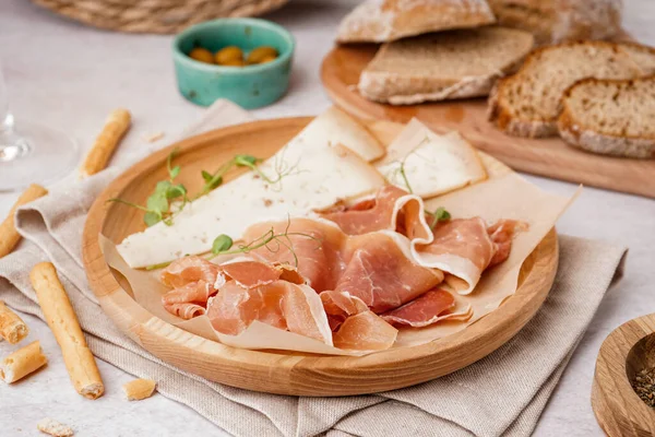 Stock image Plate with slices of tasty jamon and cheese on table