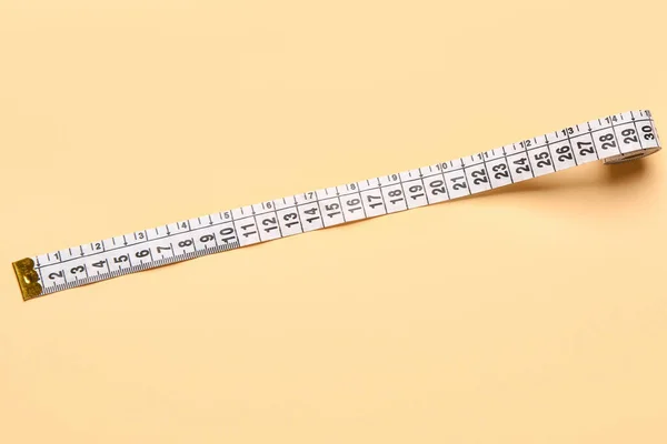 White measuring tape on beige background
