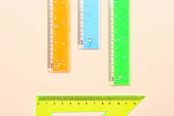 Triángulo Colorido Reglas Plástico Rectas Sobre Fondo Beige —  Fotos de Stock