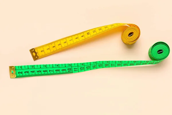 米色背景的橙色和绿色测量磁带 — 图库照片