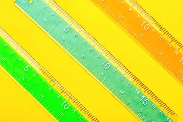 黄色背景的彩色塑料尺子 — 图库照片