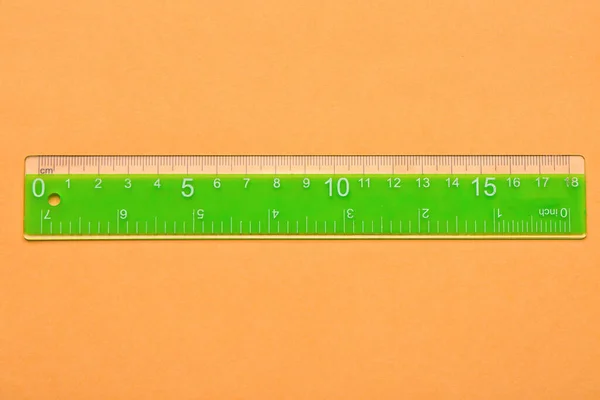 Green Plastic Ruler Orange Background — Stock Photo, Image