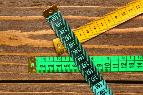 木制背景的彩色测量磁带 — 图库照片