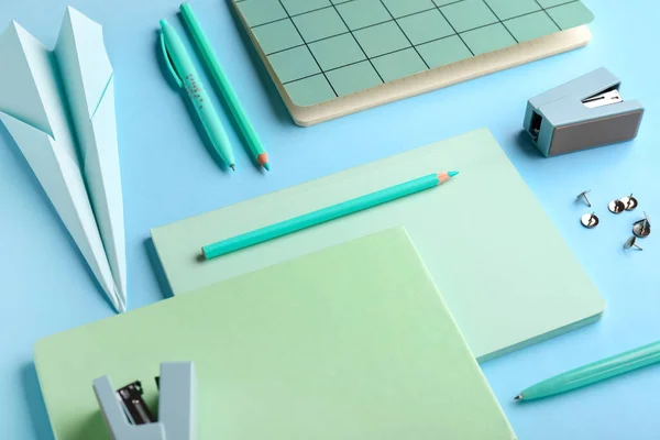 Composition with stationery supplies and paper plane on blue background