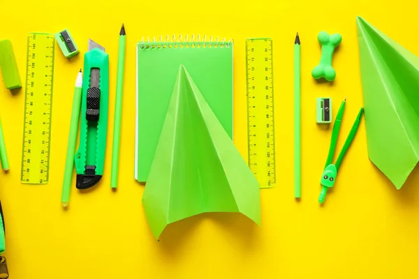 Composition with stationery supplies and paper planes on yellow background