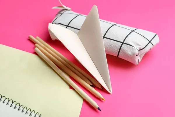 粉红背景的文具和纸飞机的组合 — 图库照片
