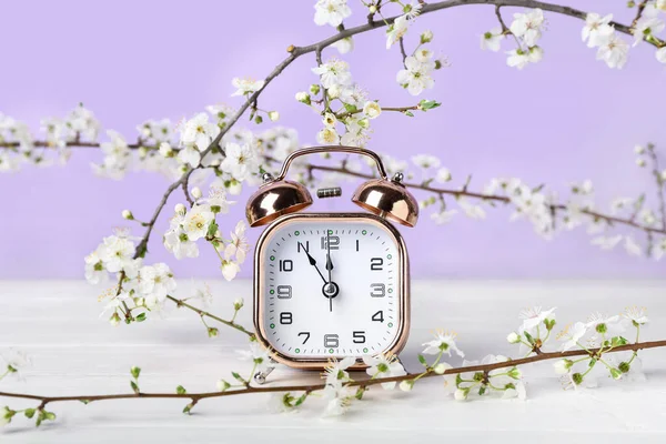 Virágzó Tavaszi Ágak Ébresztőóra Fehér Asztal Közelében Lila Fal — Stock Fotó