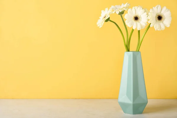 黄色の壁の近くのテーブルの上にガーベラの花の花瓶 — ストック写真