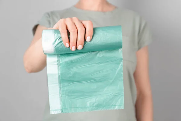 Woman Holding Roll Garbage Bags Grey Background — Stock Photo, Image