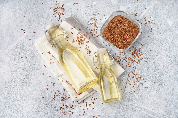 Flaschen Mit Leinöl Und Samen Auf Leichtem Grunge Hintergrund — Stockfoto