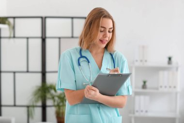 Modern klinikte belgesi olan kadın bir tıp asistanı.