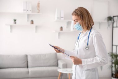 Female doctor with clipboard in modern clinic