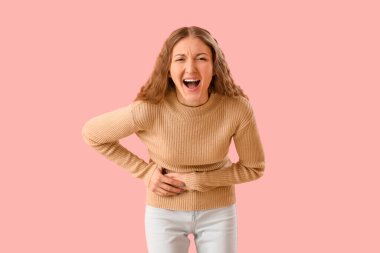 Pembe arka planda apandisiti olan genç bir kadın.