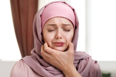 Evinde yaralı bir kadını tutan Müslüman bir adam var. Yakın plan. Aile içi şiddet kavramı