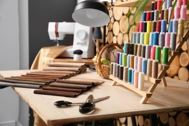 İp makaraları, makas ve kumaş örnekleriyle atölyede, yakın plan