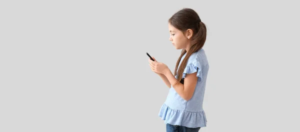 자세가 소녀가 배경으로 핸드폰을 사용하는 — 스톡 사진