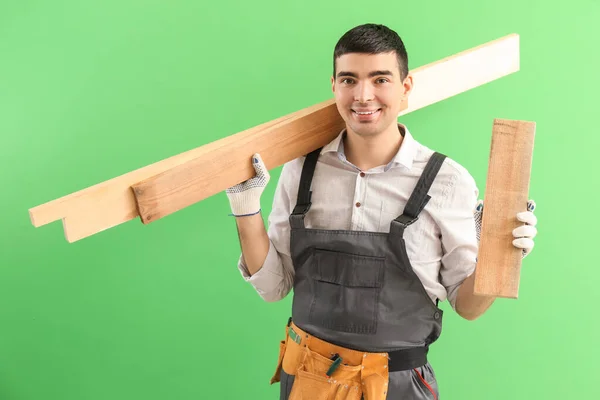 Junger Schreiner Mit Holzplanken Auf Grünem Hintergrund — Stockfoto