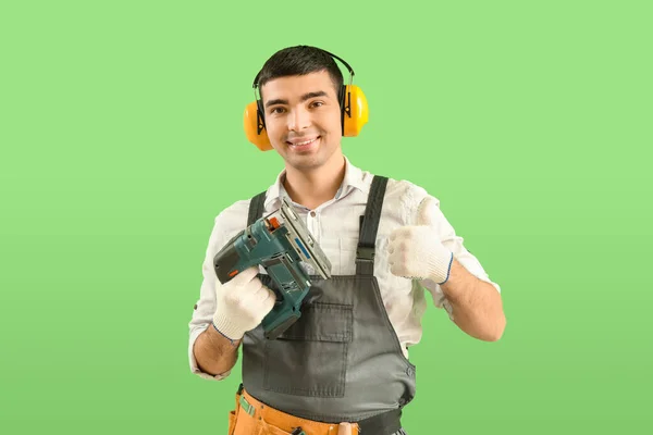 Young Carpenter Cordless Jigsaw Showing Thumb Green Background — Stock Photo, Image
