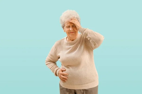Mavi Arka Planda Apandisiti Olan Yaşlı Bir Kadın — Stok fotoğraf