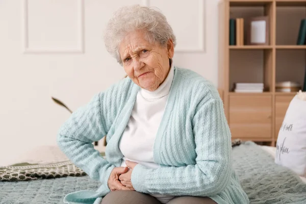Seniorin Sitzt Mit Blinddarmentzündung Schlafzimmer — Stockfoto