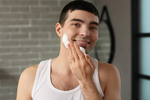 Jovem Aplicando Espuma Barbear Rosto Banheiro — Fotografia de Stock