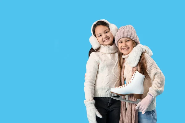 Маленькие Девочки Зимней Одежде Коньками Обнимаются Синем Фоне — стоковое фото