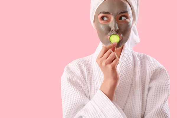 Jonge Vrouw Met Toegepaste Klei Masker Komkommer Slice Roze Achtergrond — Stockfoto