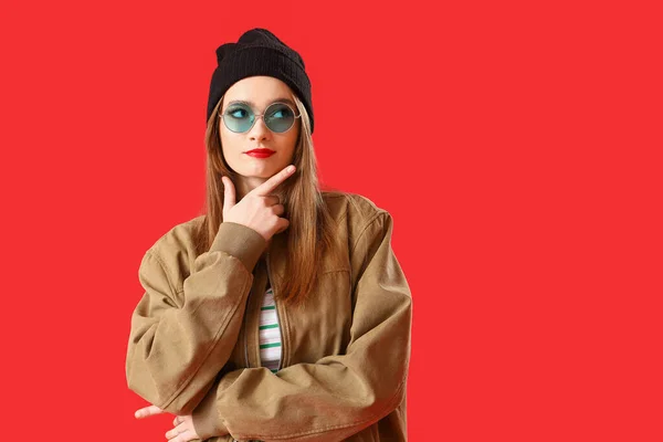 Thoughtful Young Woman Sunglasses Pointing Something Red Background — Stock Photo, Image