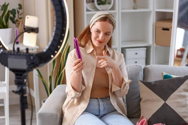 Female blogger making video review of vibrator at home