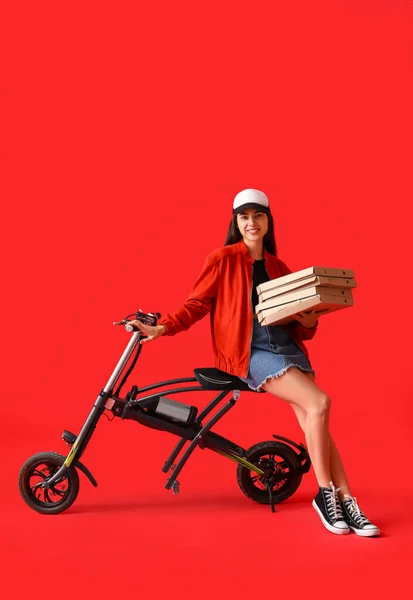 Νεαρή Γυναίκα Κουτιά Νόστιμη Πίτσα Και Ηλεκτρικό Ποδήλατο Κόκκινο Φόντο — Φωτογραφία Αρχείου