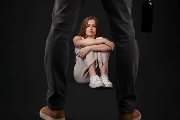 stock image Bruised young woman and her drunk husband on dark background. Domestic violence concept