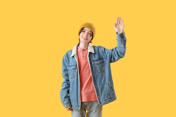 十代の少年は黄色の背景に手を振って こんにちは — ストック写真