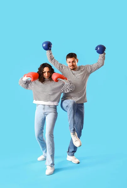 带着蓝色背景拳击手套的年轻夫妇 — 图库照片