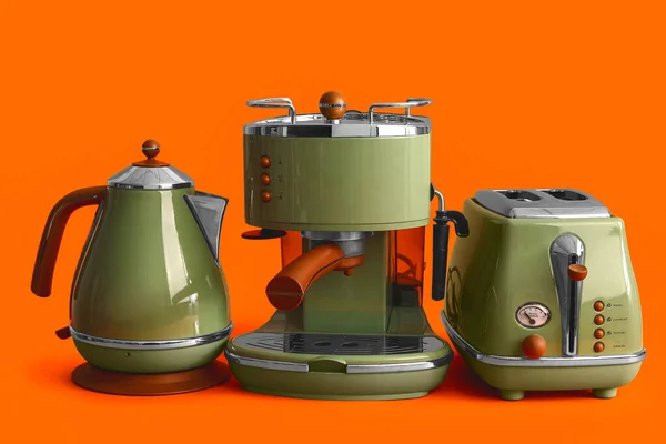 Electric kettle, coffee machine and toaster on orange background