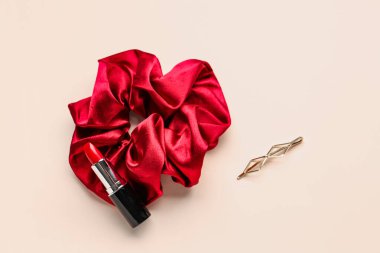 Renk arkaplanında ipek toka, saç tokası ve ruj