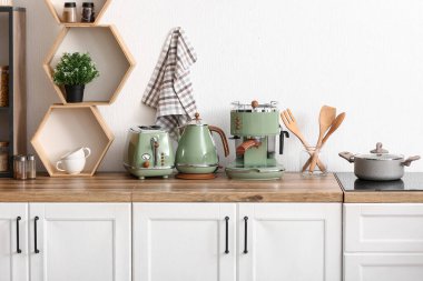 Kahve makinesi, tost makinesi ve mutfak tezgahında elektrikli su ısıtıcısı.