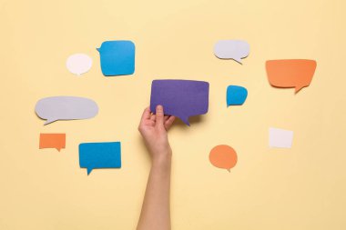 Bej arkaplanda boş konuşma balonu tutan kadının kompozisyonu