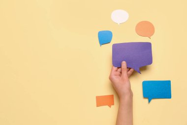 Bej arkaplanda boş konuşma balonu tutan kadının kompozisyonu