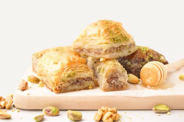 Pembe arka planda lezzetli baklava olan ahşap tahta, yakın plan.