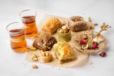 Lezzetli baklava ve arka planda bir bardak Türk çayı