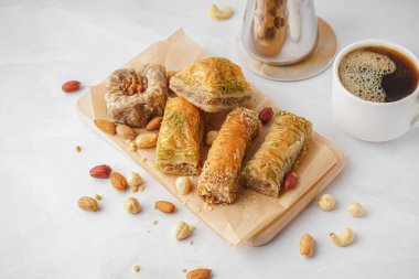 Lezzetli baklavalı ahşap tahta tahta ve arka planda bir fincan kahve.