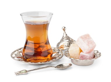 Lezzetli Türk Lokumu ve beyaz arka planda bir bardak çay.