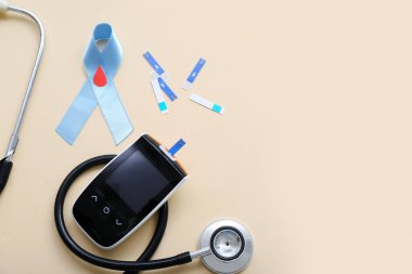 Bej arka planda glukometresi, şeritleri ve steteskopu olan farkındalık şeridi. Diyabet kavramı