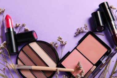 Dekoratif kozmetikten yapılmış çerçeve fırçalar ve leylak arka planda çiçekler